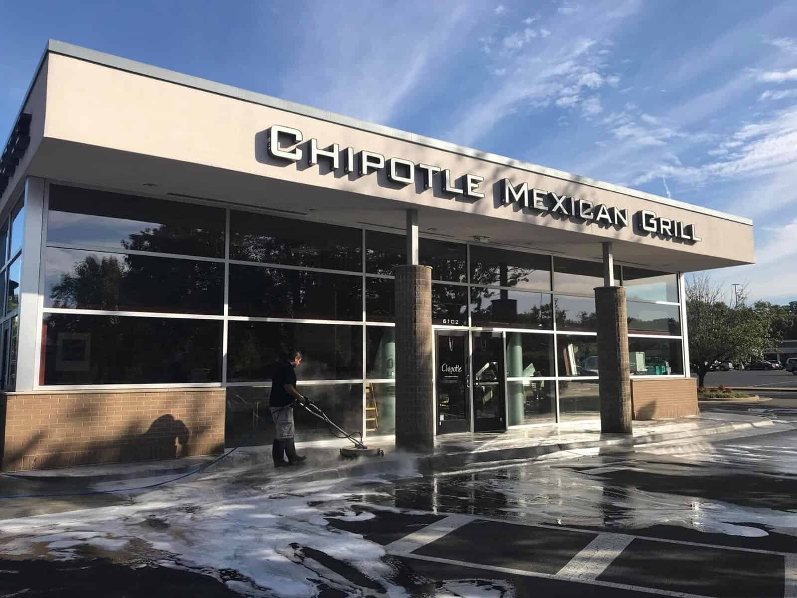 Commercial pressure washing in Raleigh & Durham NC – ProGreen technician cleaning building and sidewalks